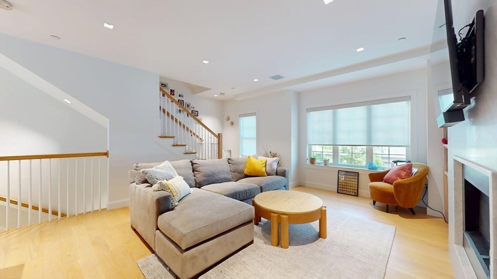 21 Crowninshield Road, Unit 17 Brookline, MA 02446 - Photo 8 of 29 a living room with furniture a flat screen tv and a large window