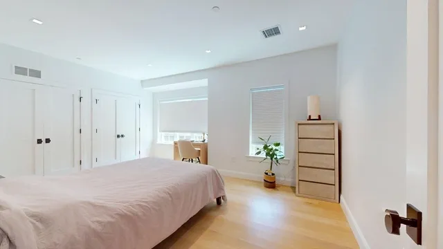 a spacious bedroom with a bed and a cabinets