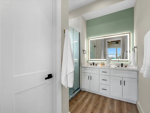 a bathroom with a double vanity sink mirror and shower