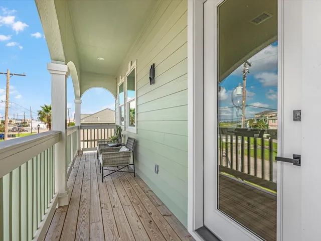 a view of a balcony with furniture and wooden floor