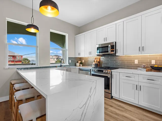 a kitchen with stainless steel appliances granite countertop a stove a sink and a microwave