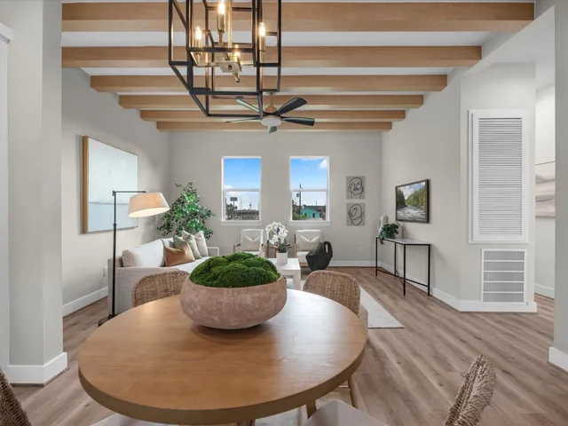 a kitchen with kitchen island stainless steel appliances a dining table chairs and chandelier