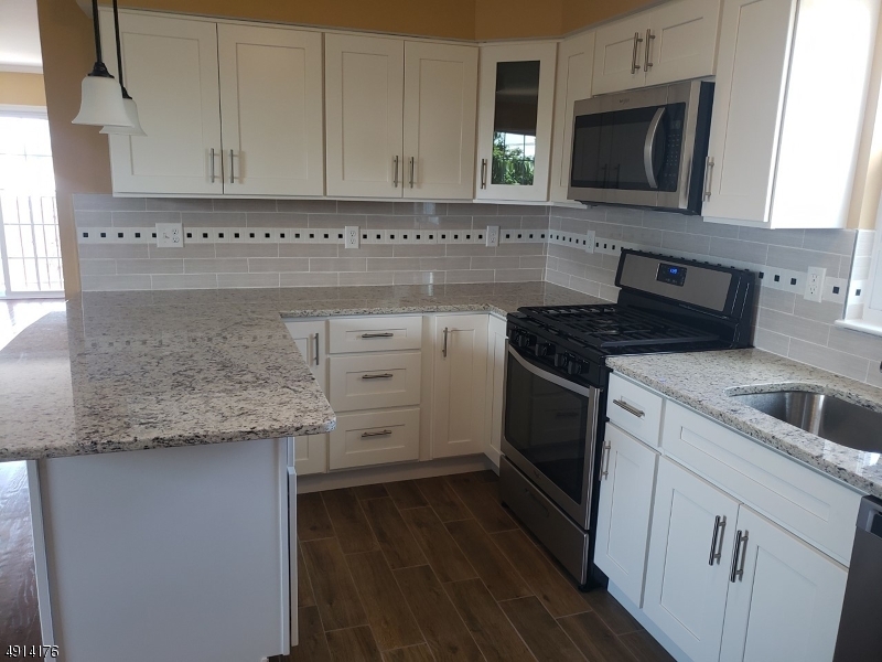 230 Erie Street, Unit 3 Elizabeth Port, NJ 07206 - Photo 3 of 6 a kitchen with granite countertop a stove and a sink