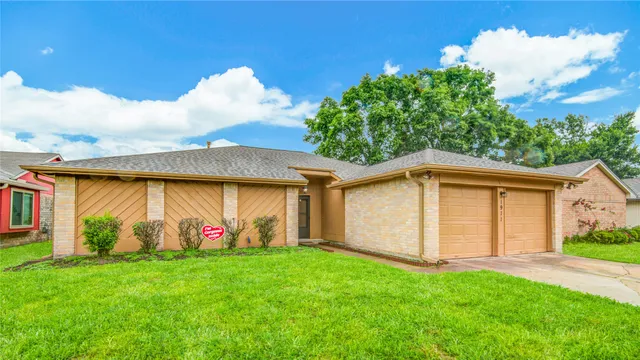 a view of a white house with a big yard and large tree