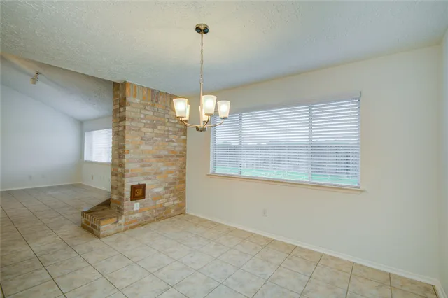 a view of a livingroom with a chandelier fan and windows