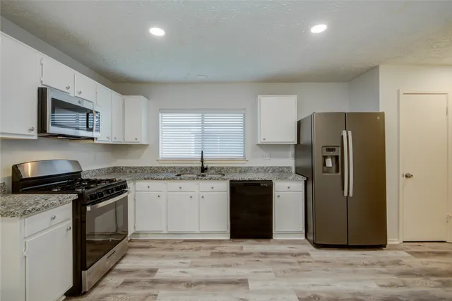 a kitchen with a refrigerator stove top oven and sink