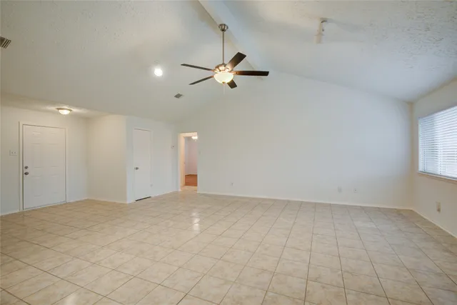 an empty room with fan and windows