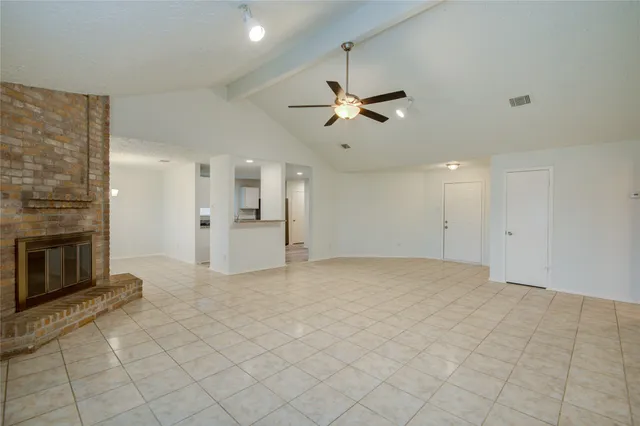 a view of a livingroom with a ceiling fan a fireplace and a chandelier fan