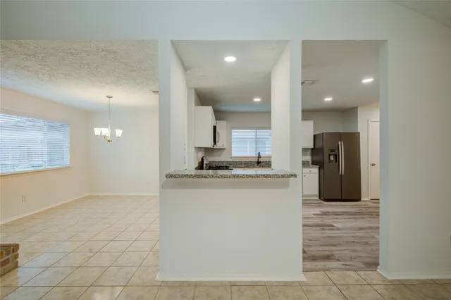 a kitchen with a sink a refrigerator and black cabinets