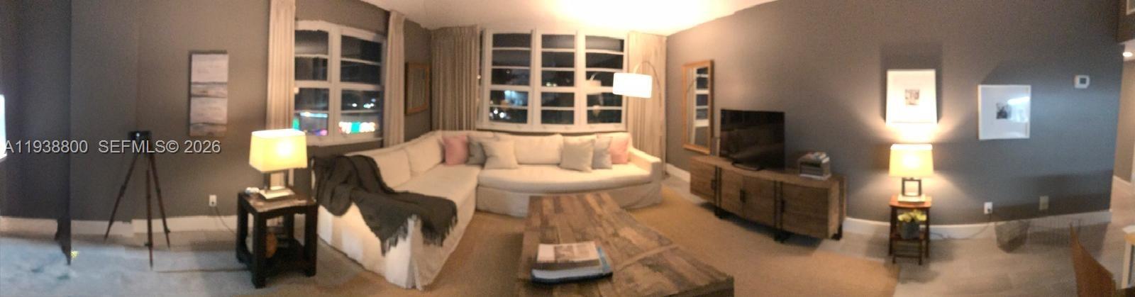 a living room with furniture and a floor to ceiling window