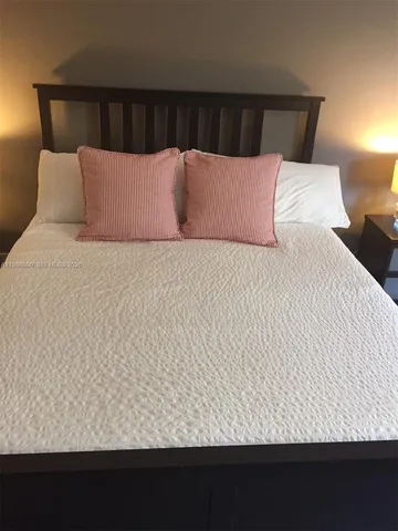 a bed sitting in a bedroom with a lamp