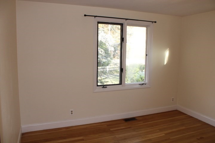 34 R Summer Street Rockport, MA 01966 - Photo 17 of 22 an empty room with wooden floor and windows