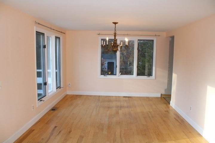 34 R Summer Street Rockport, MA 01966 - Photo 10 of 22 a view of an empty room with a window and wooden floor