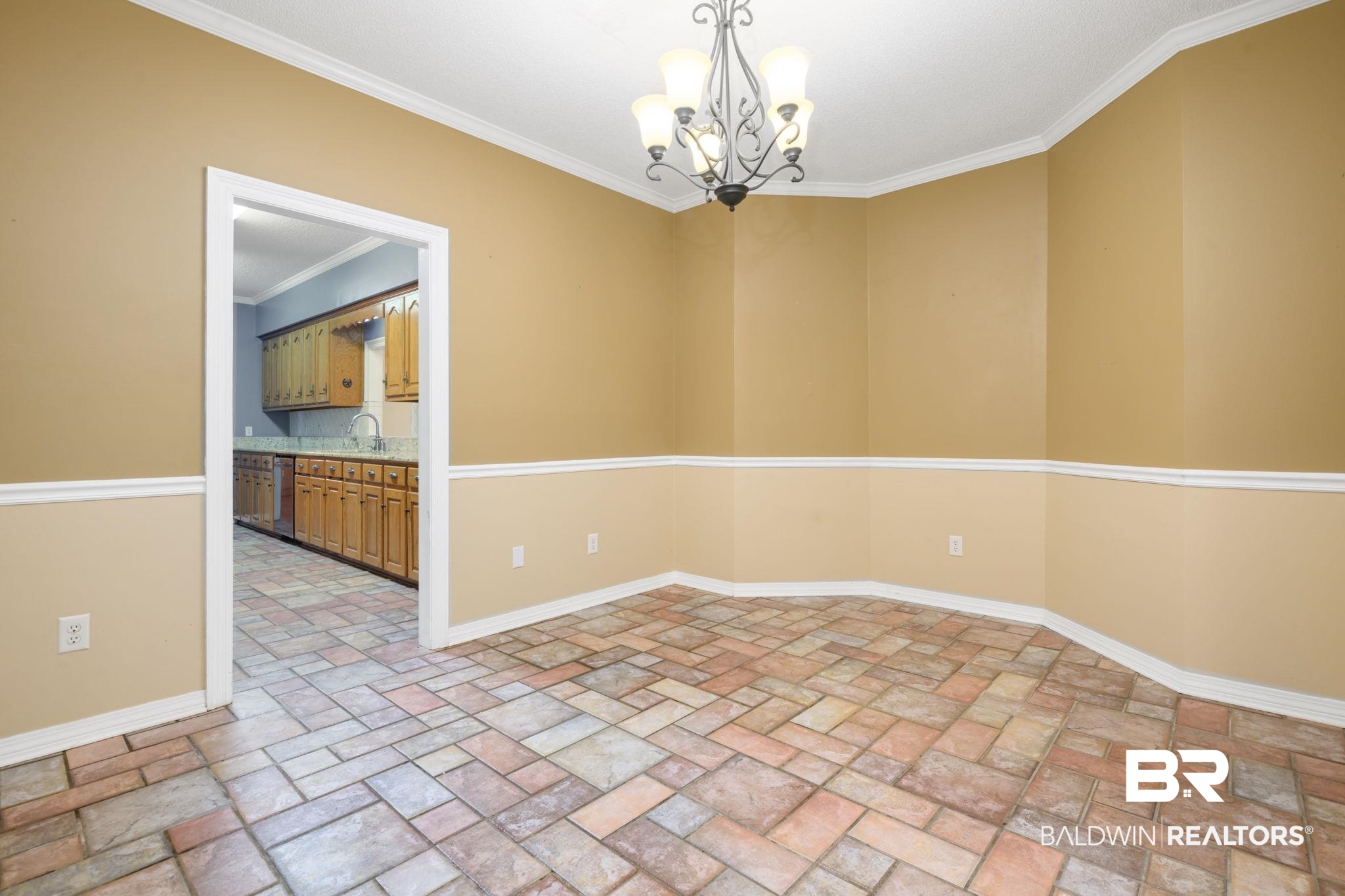 7540 2 Mile Road Irvington, AL 36544 - Photo 25 of 82 Spacious room with multicolored tile flooring, chair rail molding, and a decorative chandelier