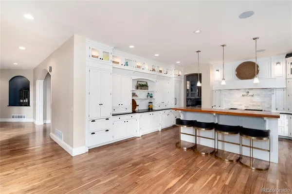 a kitchen with granite countertop a stove a sink a center island and wooden floor