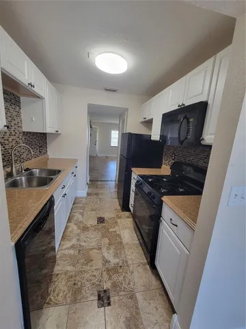 a large kitchen with a stove a sink and a refrigerator