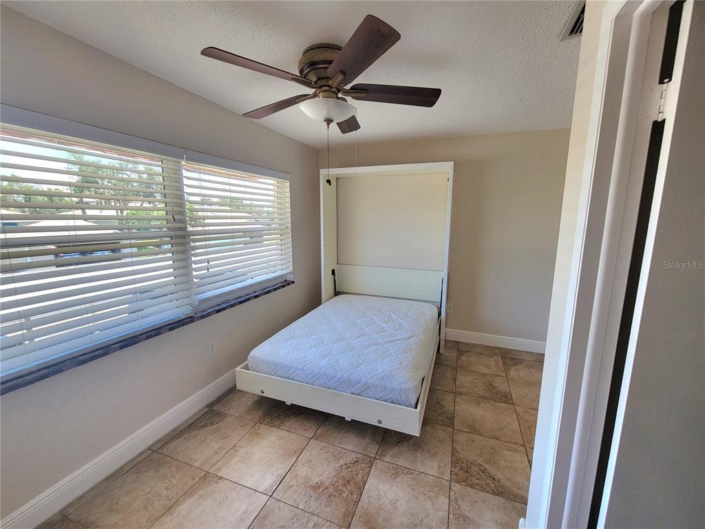 10032 65th Avenue North, Unit 19 St. Petersburg, FL 33708 - Photo 18 of 44 a bedroom with a bed and a large window
