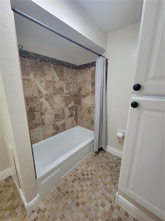 10032 65th Avenue North, Unit 19 St. Petersburg, FL 33708 - Photo 23 of 44 a bathroom with a bathtub and a shower