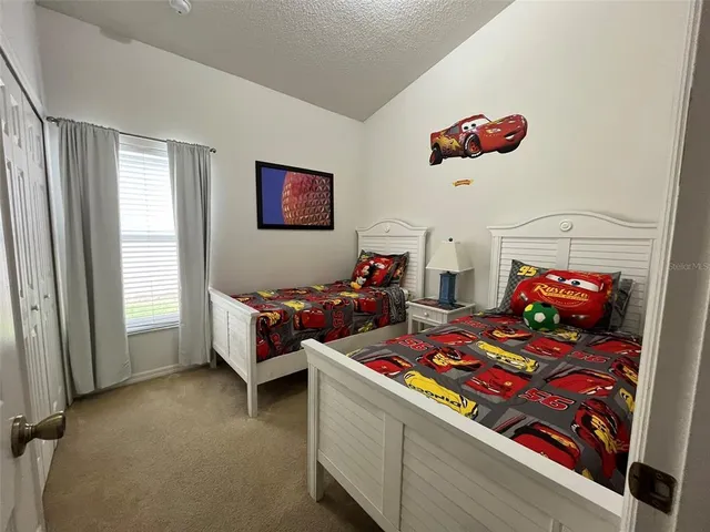 a bedroom with two beds and a chandelier