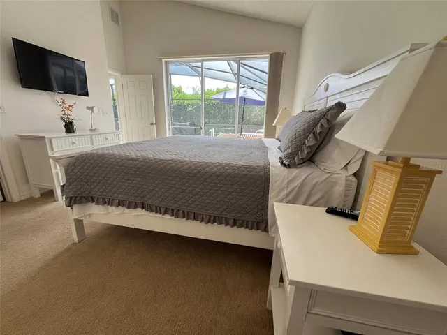 a bedroom with a bed tv and window
