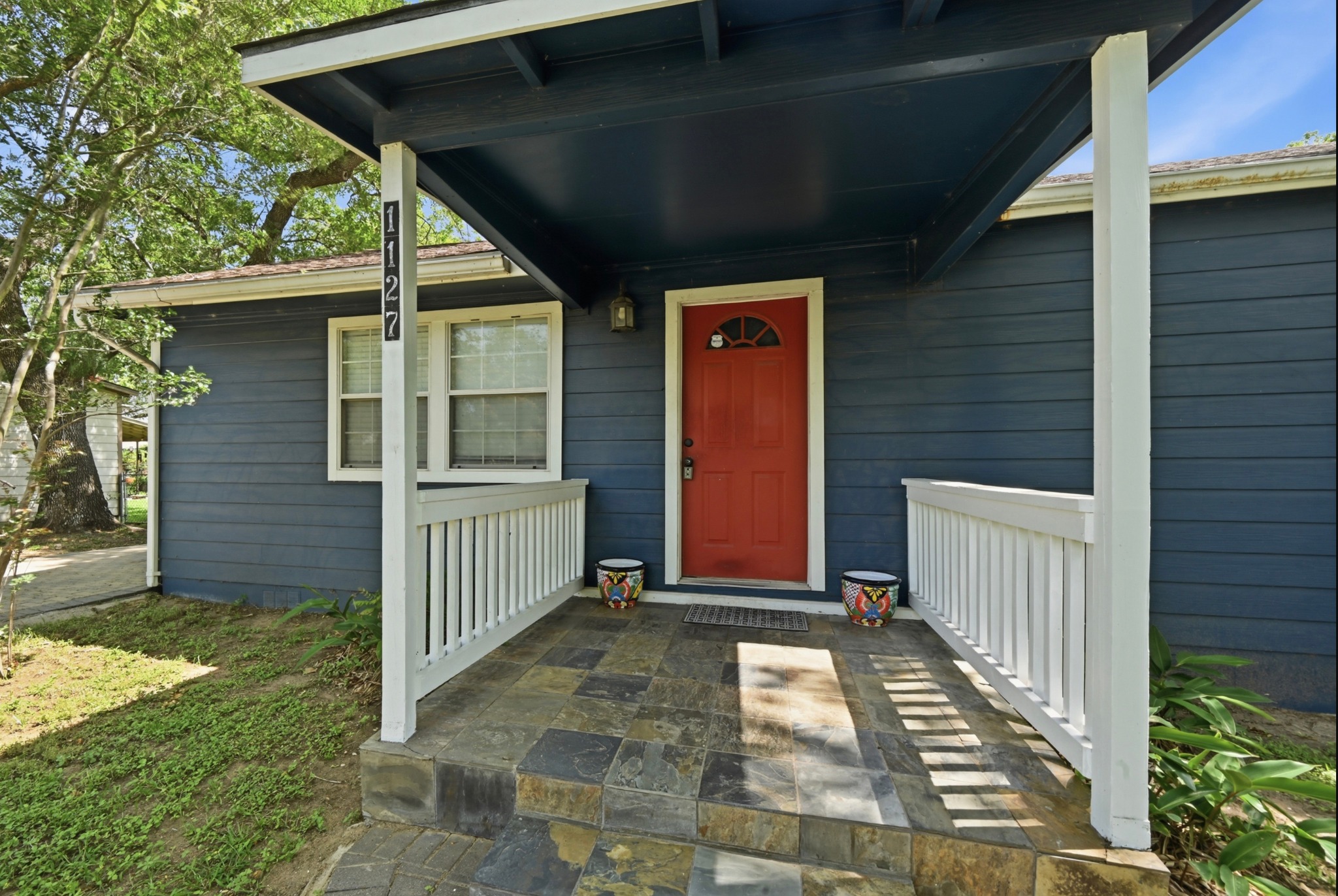 1127 Parr Street Luling, TX 78648 - Photo 4 of 20 A welcoming covered porch with slate tile flooring and white railings complements this charming home's entrance.