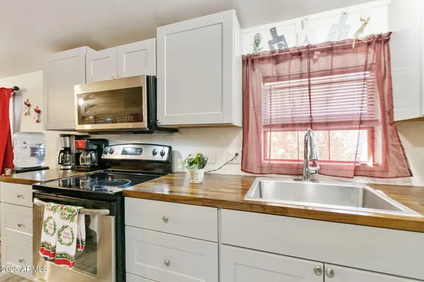 a kitchen with granite countertop a stove a sink and a microwave