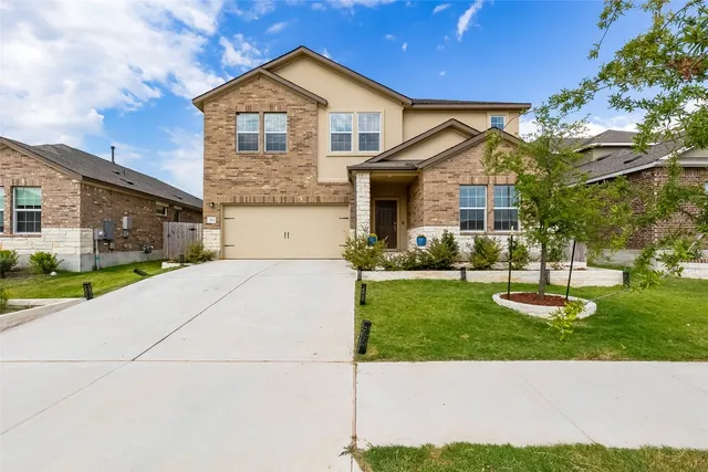 a front view of a house with a yard and garage