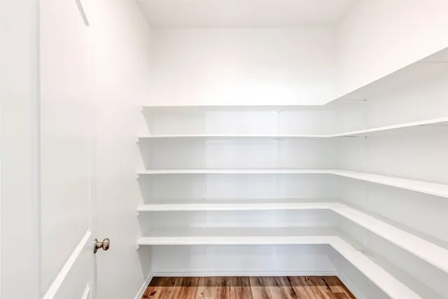 a view of kitchen with kitchen island a sink wooden floor and a refrigerator