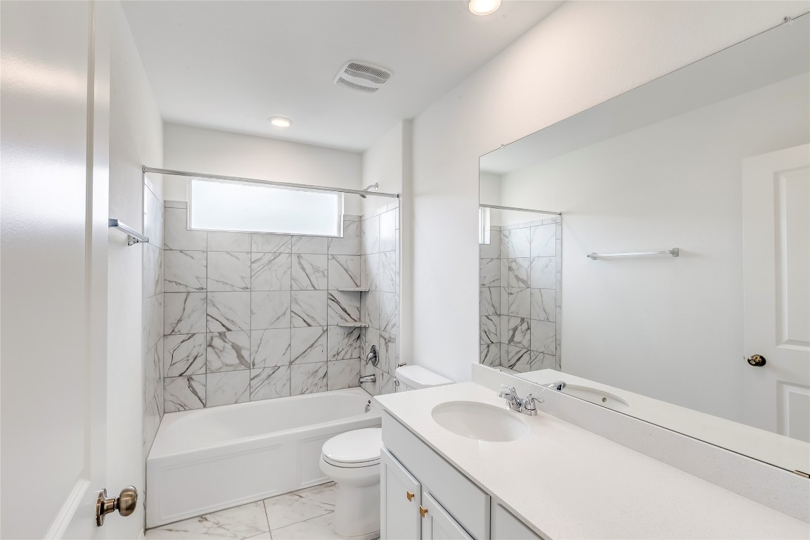 2113 Guntersville Bend Leander, TX 78641 - Photo 30 of 40 a bathroom with a bathtub shower sink vanity mirror and toilet