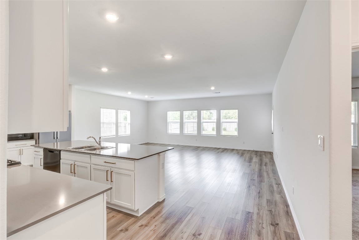 2113 Guntersville Bend Leander, TX 78641 - Photo 7 of 40 a kitchen with stainless steel appliances a kitchen island hardwood floor sink stove and wooden cabinets