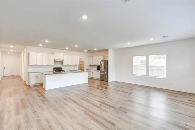 a large kitchen with stainless steel appliances and a refrigerator