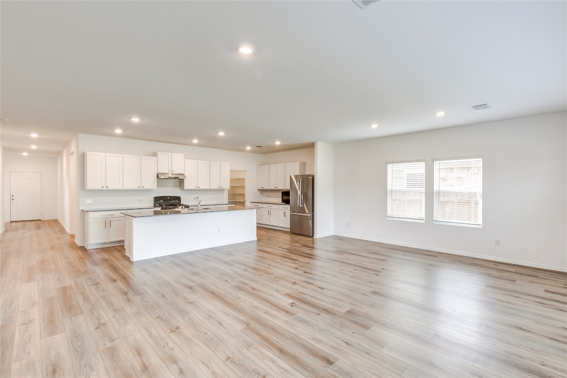 2113 Guntersville Bend Leander, TX 78641 - Photo 10 of 40 a view of kitchen with kitchen island sink refrigerator and white cabinets