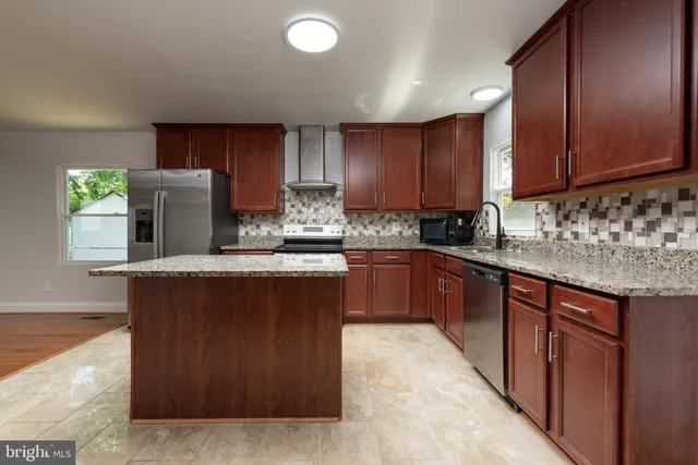 a kitchen with stainless steel appliances granite countertop wooden cabinets a sink and dishwasher