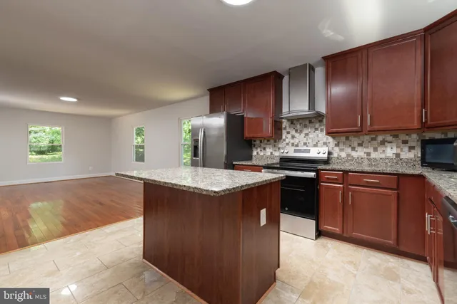 a kitchen with stainless steel appliances granite countertop wooden cabinets a sink and dishwasher