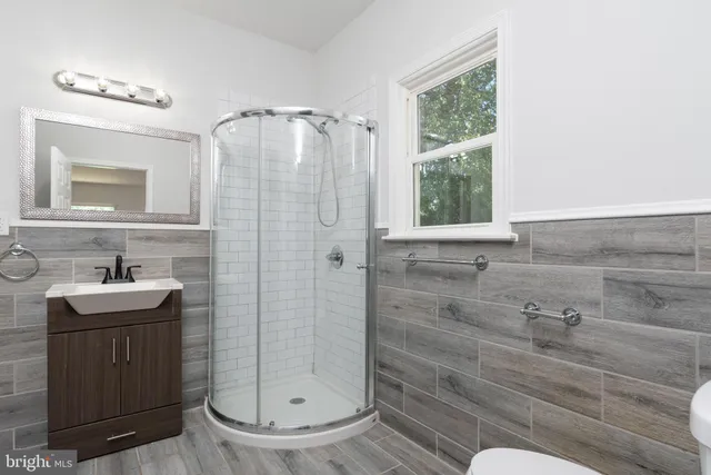 a bathroom with a granite countertop sink a mirror a window and vanity