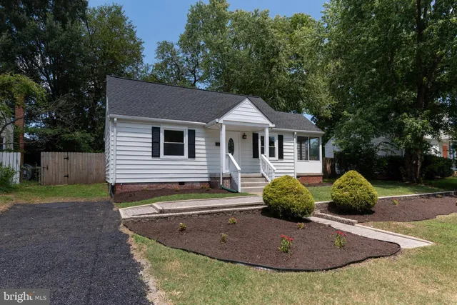 a view of a house with a backyard and trees