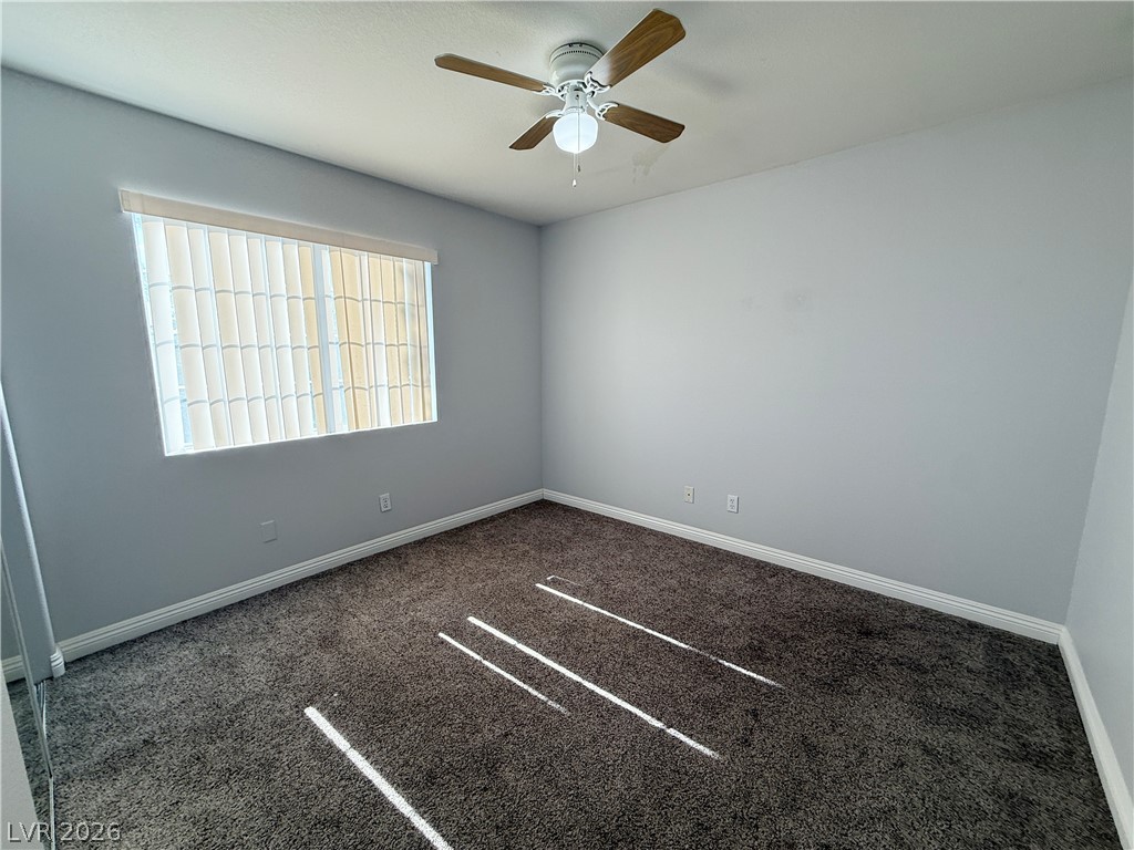 2185 Polynesia Circle Henderson, NV 89074 - Photo 17 of 37 A well-lit bedroom features plush carpeting and a convenient ceiling fan for comfort.