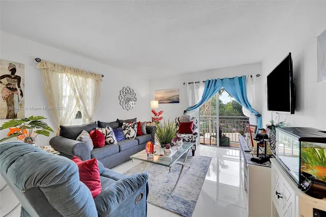 a living room with furniture a flat screen tv and a large window