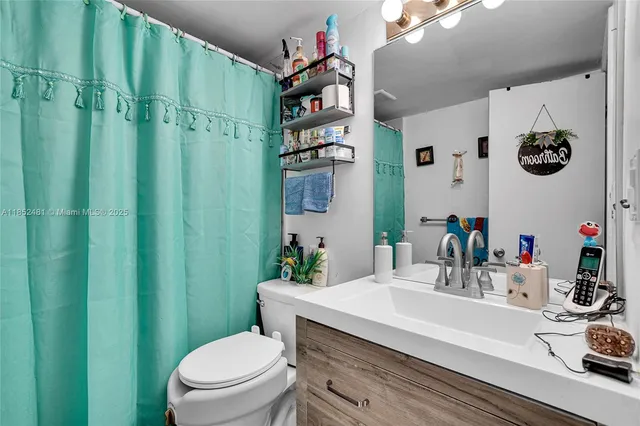 a bathroom with a sink a toilet and shower curtain
