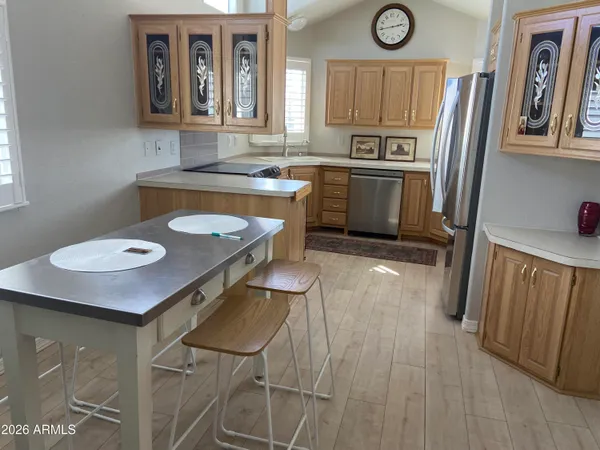 a kitchen with stainless steel appliances granite countertop a sink a stove a refrigerator a microwave oven with white cabinets and wooden floor