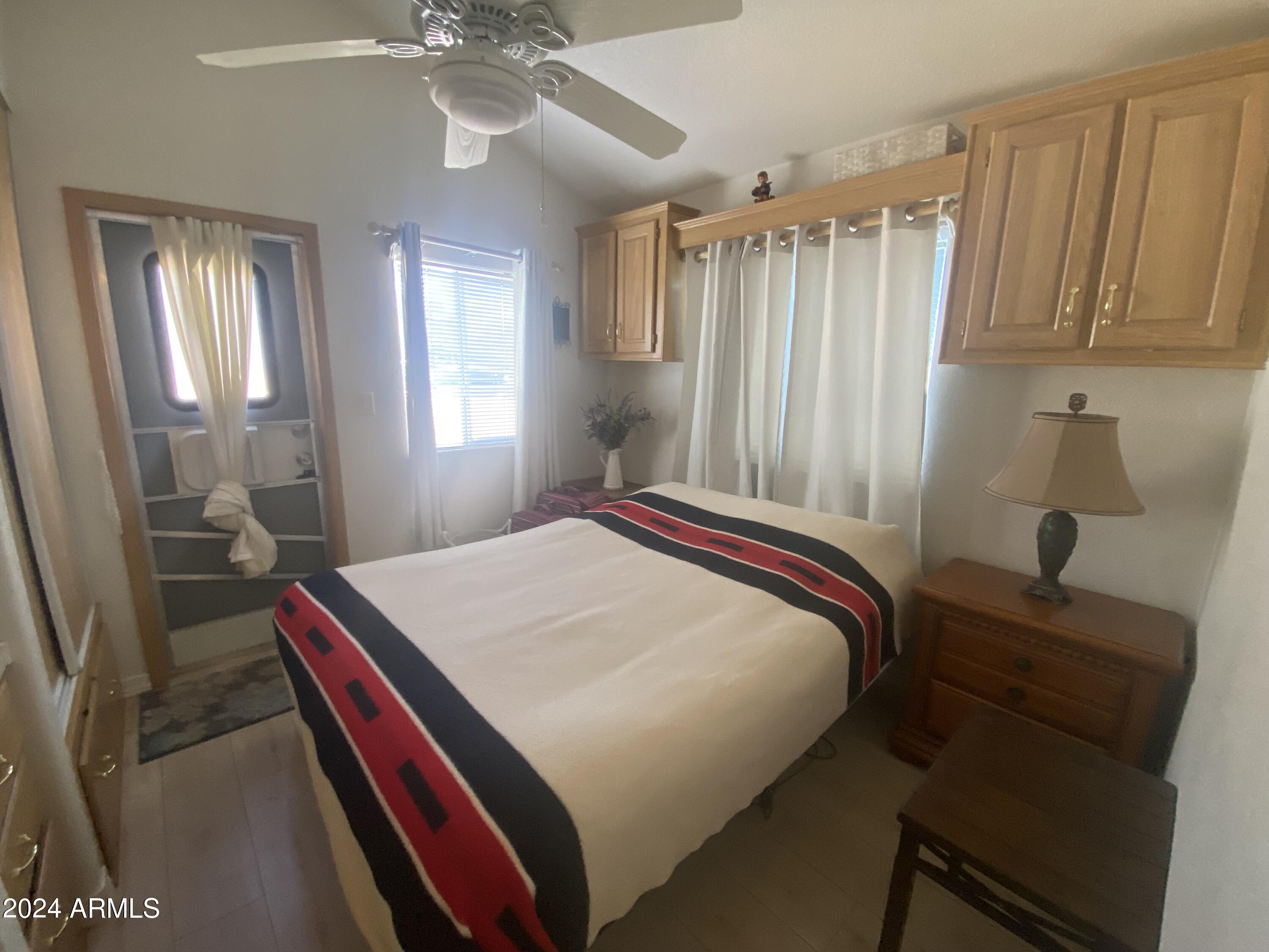 2066 West Klamath Avenue, Unit 66 Apache Junction, AZ 85119 - Photo 16 of 35 a bedroom with a bed and a chandelier