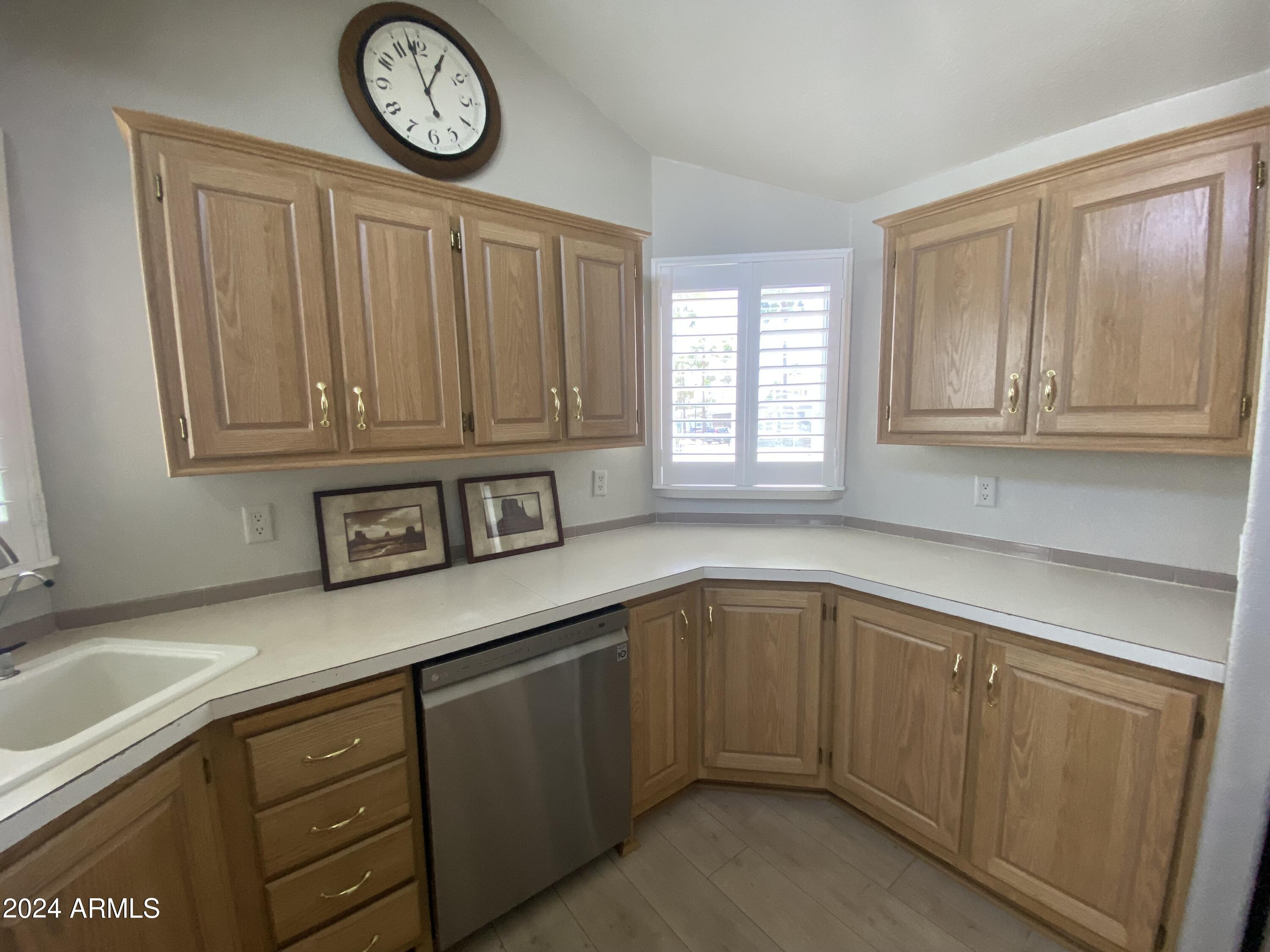 2066 West Klamath Avenue, Unit 66 Apache Junction, AZ 85119 - Photo 2 of 35 a kitchen with stainless steel appliances granite countertop a sink and dishwasher with wooden cabinets