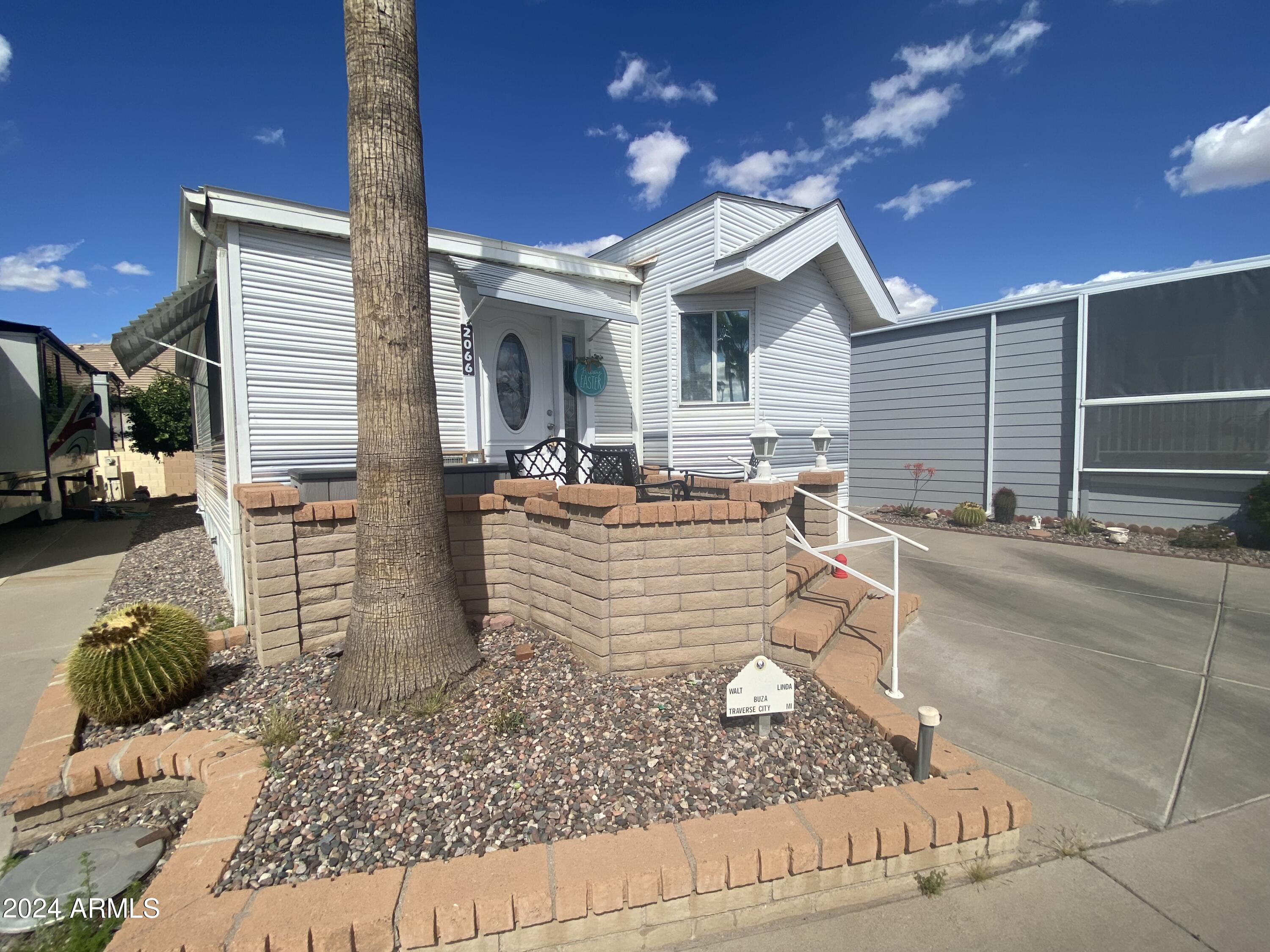 2066 West Klamath Avenue, Unit 66 Apache Junction, AZ 85119 - Photo 27 of 35 a view of a patio with couches and chairs with wooden floor and plants