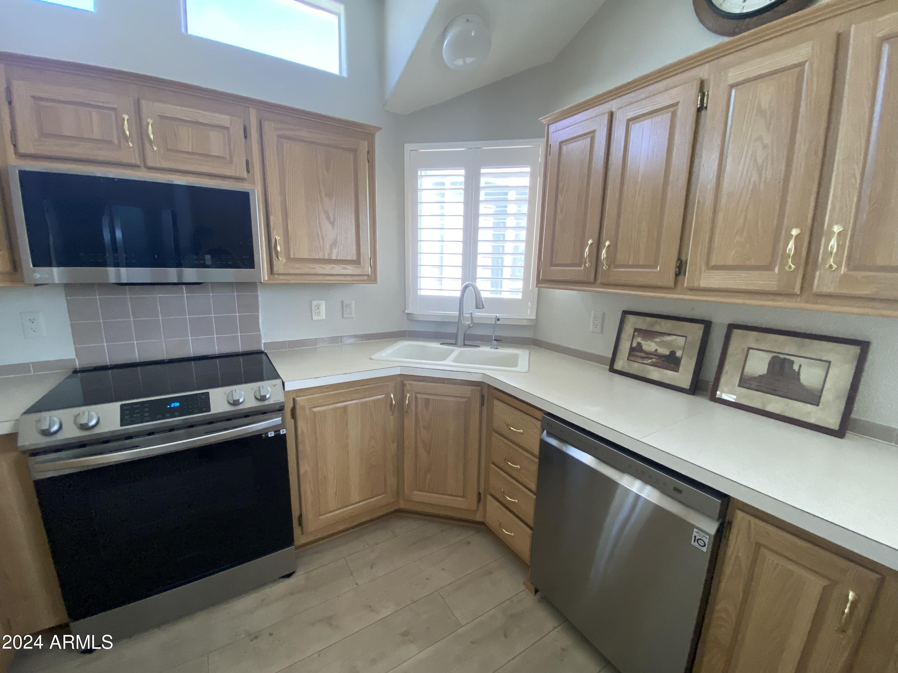2066 West Klamath Avenue, Unit 66 Apache Junction, AZ 85119 - Photo 3 of 35 a kitchen with stainless steel appliances granite countertop a stove a sink and a microwave