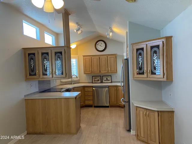 a kitchen with granite countertop a sink a stove top oven and cabinetry