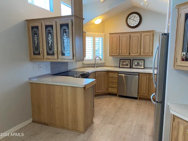 a kitchen with stainless steel appliances granite countertop a sink and a stove with wooden floor
