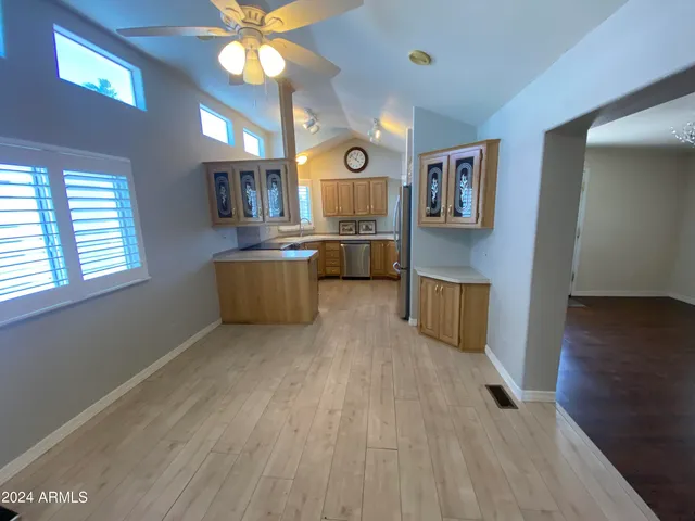 a living room with stainless steel appliances kitchen island granite countertop furniture and a wooden floor