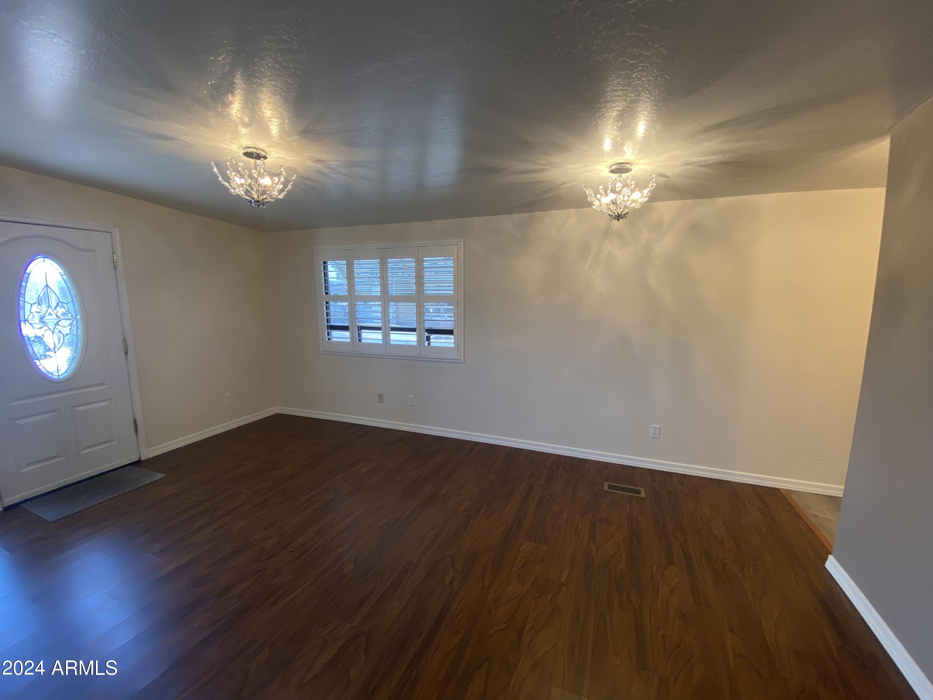 2066 West Klamath Avenue, Unit 66 Apache Junction, AZ 85119 - Photo 10 of 35 wooden floor in an empty room with a window