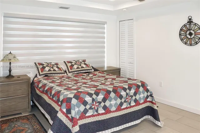 a bedroom with a bed and painting on the wall