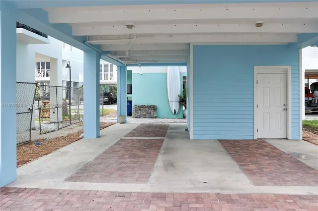 a view of a hallway with wooden floor and a living room